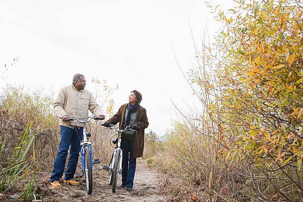 coppia biciclette di spinta - adult autumn couple face to face foto e immagini stock