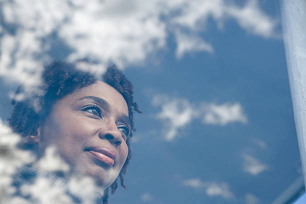 portrait d'une femme - regarder par la fenêtre photos et images de collection