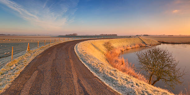 istock Typical Dutch landscape with a dike, in winter at sunrise 534418957