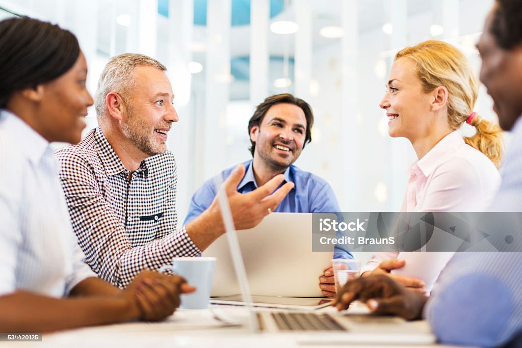 Happy business people on a meeting. Group of smiling business people having a meeting in the office and talking. 2015 Stock Photo