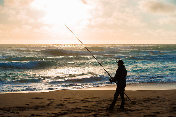 istock Man fishing on Beach at Sunset 534420511