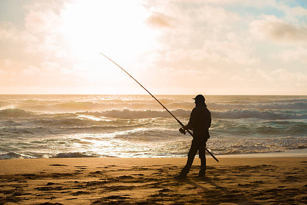 Man fishing on Beach at Sunset