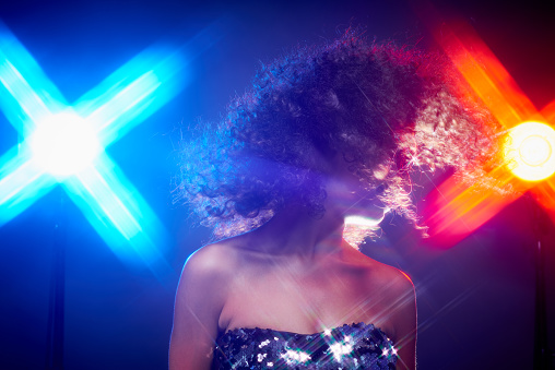 Woman dancing in disco lights, her hair flying