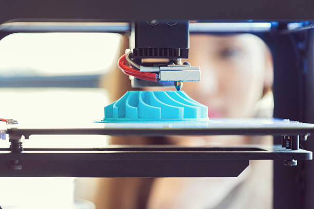 3D printout Young woman watching 3D printout. Focus on blue printout. polymer stock pictures, royalty-free photos & images