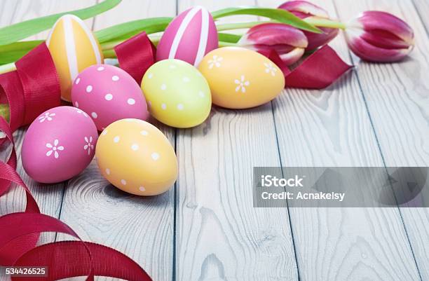 Colorful Easter Eggs And Ribbon On Wooden Background Stock Photo - Download Image Now