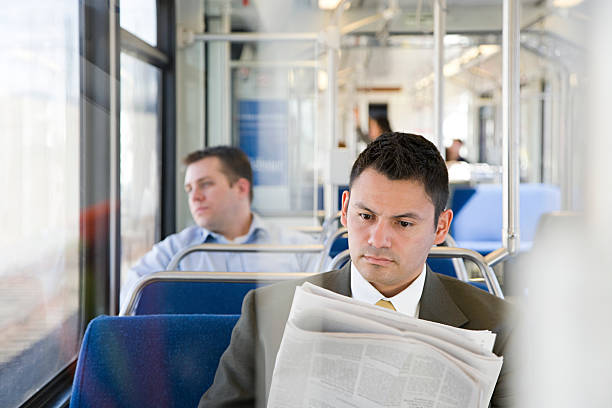 istock Businessman reading newspaper on train 534428845