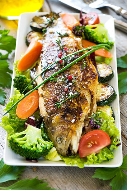 istock Grilled trout with vegetables on wooden background 534447112