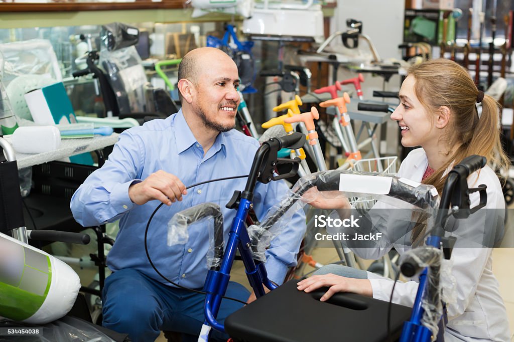 Client asking girl about electric wheelchairs Client asking girl about electric wheelchairs in store Store Stock Photo