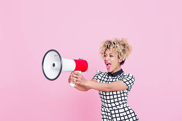 Afro American young woman shouting into megaphone