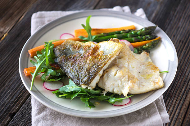 istock Fish fillet with vegetables on wooden background 534456632