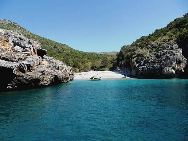 Marina di Camerota, Salerno, Campania, Italy - April 28, 2012: Small white sand beach along Camerota coast. Considered one of the most beautiful beaches in Italy, it is part of the National Park of Cilento and Vallo di Diano, protected by UNESCO since 1997
