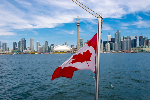 Canadian flag with the Toronto Skyline in the Background. The city offers boat tours which are very popular with tourists and visitors to the Financial Capital of Canada