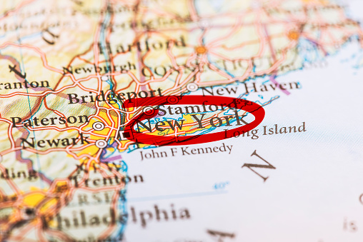 New York city circled with red marker on map. Close up shot.