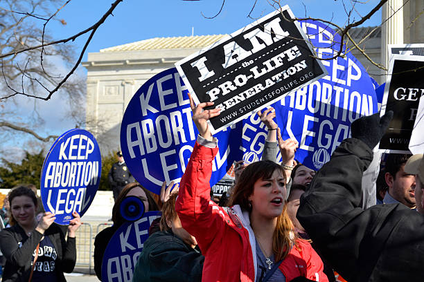 Protesters Chanting At The U.S. Supreme Court Washington D.C., USA - January 22, 2015; A Pro-Life woman clashes with a group of Pro-Choice demonstrators at the U.S. Supreme Court.  political rally photos stock pictures, royalty-free photos & images