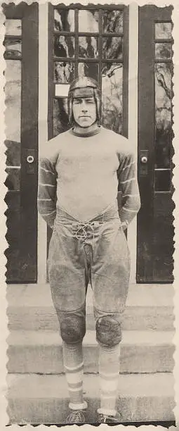 Football player in front of Keota High School, Keota, Iowa, USA, 1943.