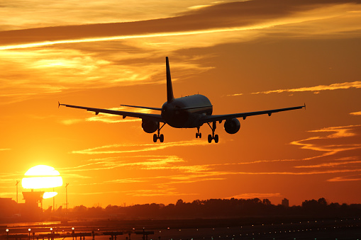 An airplane landing at an airport during sunset on vacation during a journey