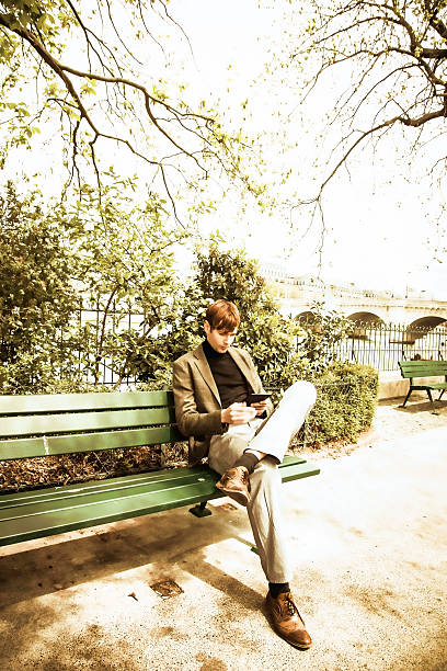 istock handsome young man reading on a park bench, Paris, France 534476706