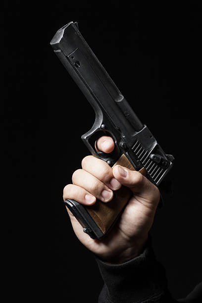istock male hand with gun isolated on black background 534479045