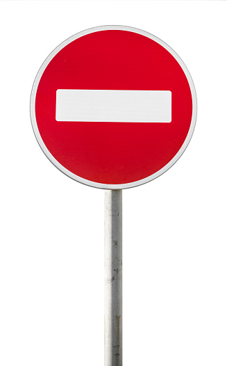 Round red road sign on metal pole. No Entry road-sign mounted on urban roadside