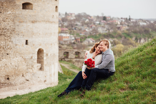 Happy smiling couple having fun outdoors near a medieval castle