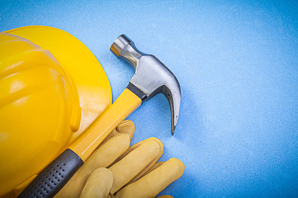 istock Claw hammer safety gloves building helmet on blue background con 534495650