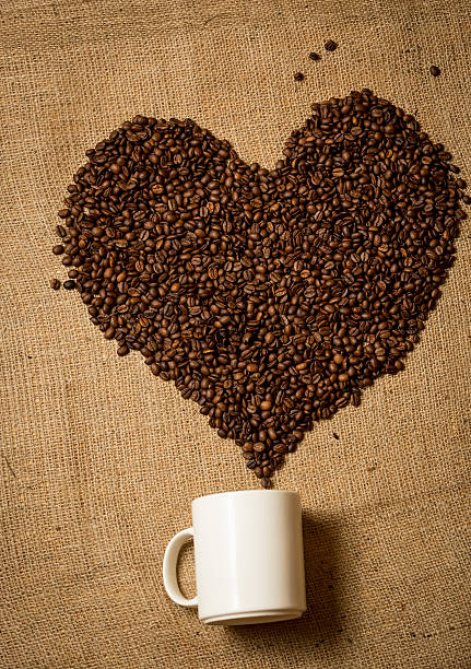 istock heart of coffee beans going from white mug 534500873