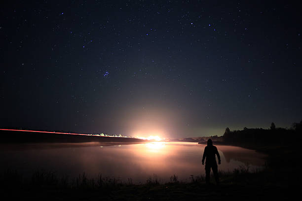 istock night man at Lake starry sky space alien 534501641