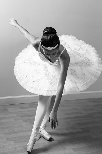 Close up black and white image of an oriental Ballet Dancer practicing at the ballet studio