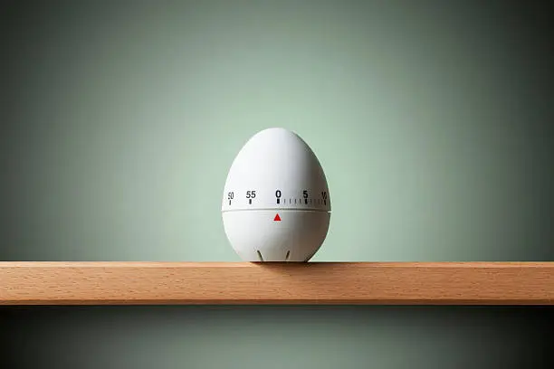 Kitchen egg timer on the shelf.