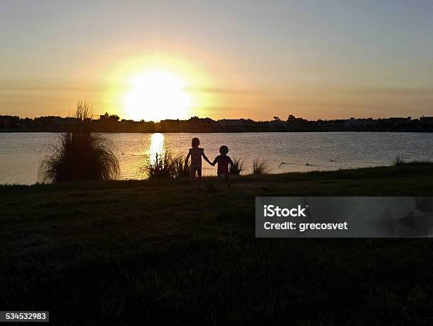 Sunset Kids Couple Silhouette Stock Photo - Download Image Now - 2015, Back Lit, Brother