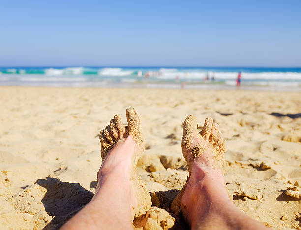 istock Unusual look past bare male feet at a beautiful beach 534535925