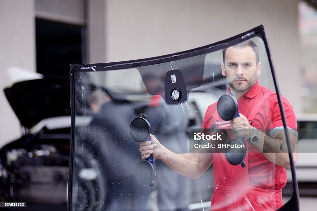 windshield replace man with old windshield in workshop Windshield Stock Photo