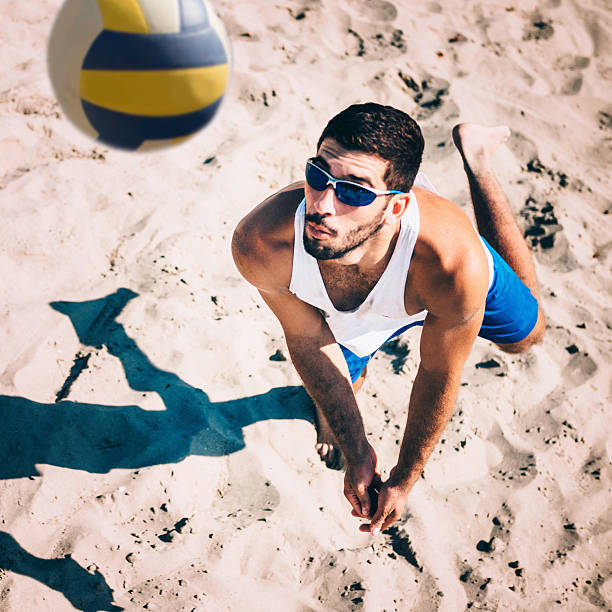 jugador de vóley playa de recibir la bola, acción de disparo - vóleibol de playa fotografías e imágenes de stock