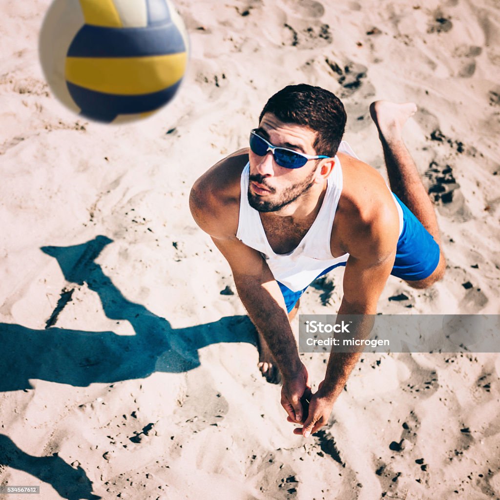 Beach volleyball player receiving the ball, action shot Beach Volleyball Stock Photo
