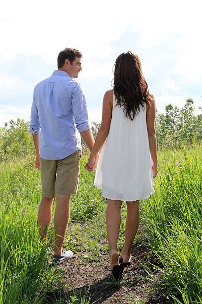 istock Man gazing at woman walking holding hands 534567850