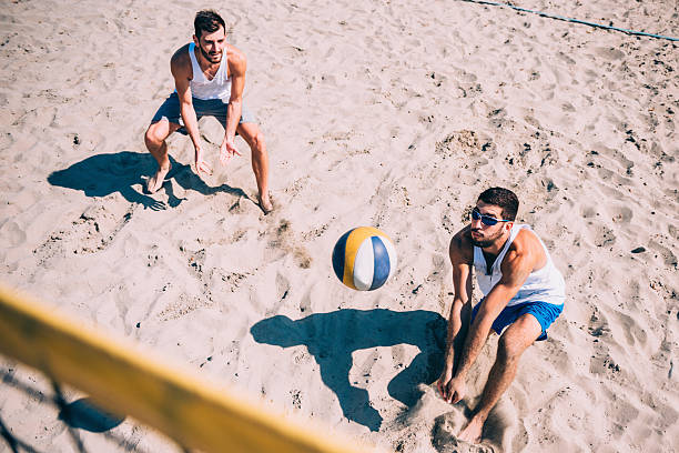 compétition de volley de plage, hommes jouer - ballon de volley photos et images de collection