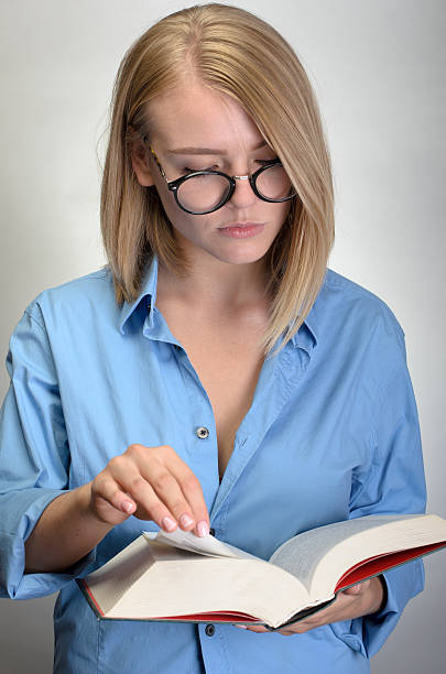 istock young pretty woman in glasses reading a book 534569216