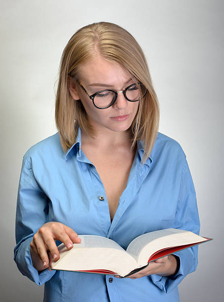 istock young pretty woman in glasses reading a book 534569310