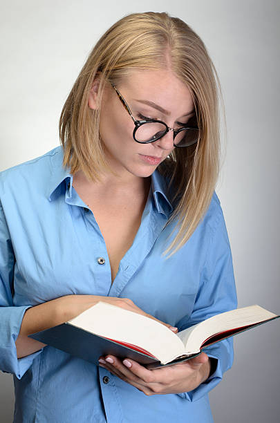 istock young pretty woman in glasses reading a book 534569490