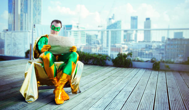 супергерой читает газету на крыше города - reading newspaper 30s adult стоковые фото и изображения