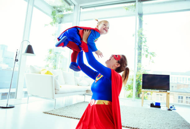 istock Superhero playing with baby in living room 534573681