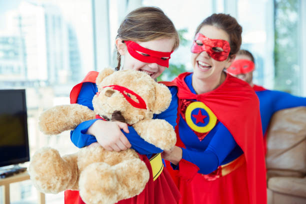 istock Superhero mother and daughter playing with teddy bear 534573779