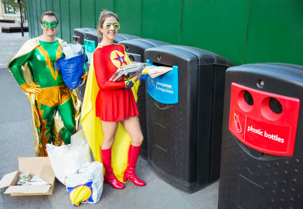 casal de super-heróis reciclando na calçada da cidade - recycling green environment superhero - fotografias e filmes do acervo