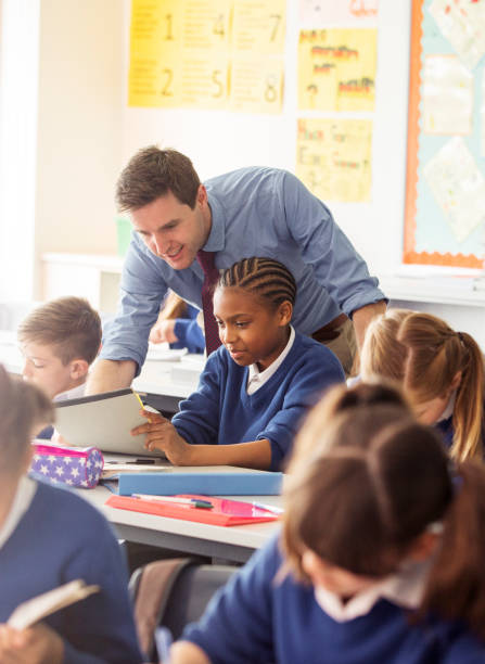 istock Teacher with his pupils in classroom 534575783