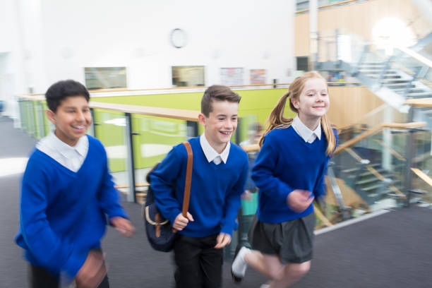 istock Happy pupils wearing school uniforms running in school corridor 534575893