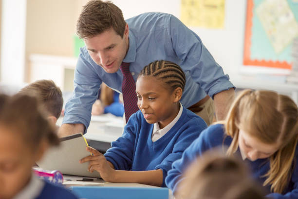 Teacher with his pupils in classroom  high school teacher stock pictures, royalty-free photos & images