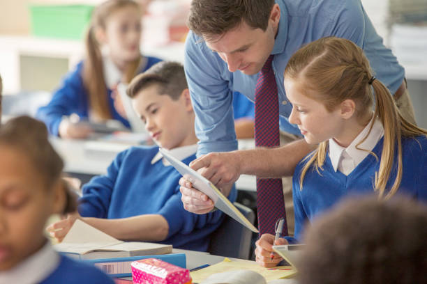 enseignant avec ses élèves en classe à l’aide d’une tablette pc - outer london photos et images de collection