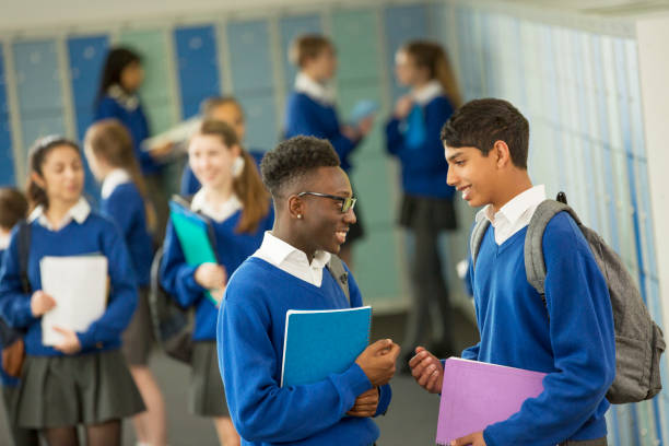 istock Two male students wearing school uniforms talking in locker room 534576129
