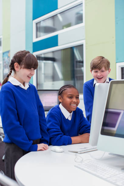 istock Primary school children looking at computer and smiling 534576517