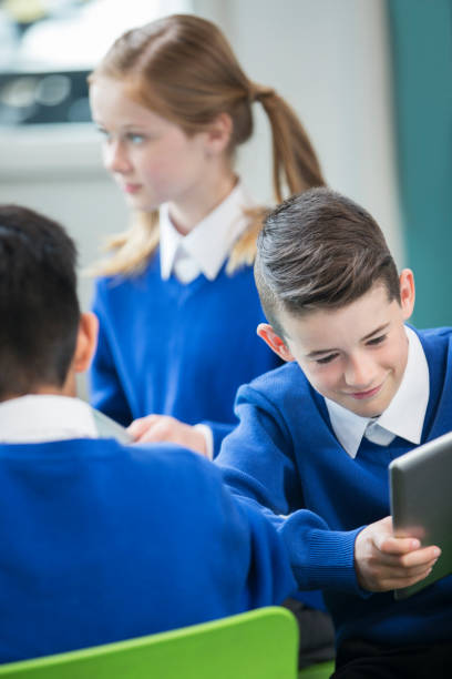 istock Elementary school children wearing blue school uniforms in classroom 534576751
